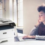 Young woman working at her computer next to a Xerox® B315 multifunction printer.