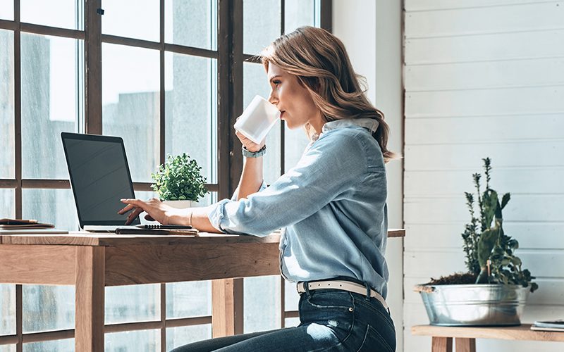 Woman working in home office at her computer with Xerox® Docushare® Go solution